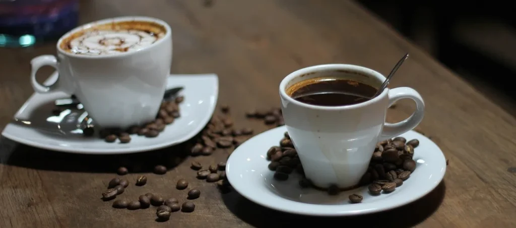 prawidlowe picie espresso espresso podane w małej filiżance z łyżeczką, obok stoi druga kawa